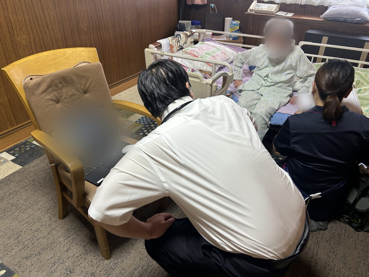 訪問先で診療記録を入力する医師
