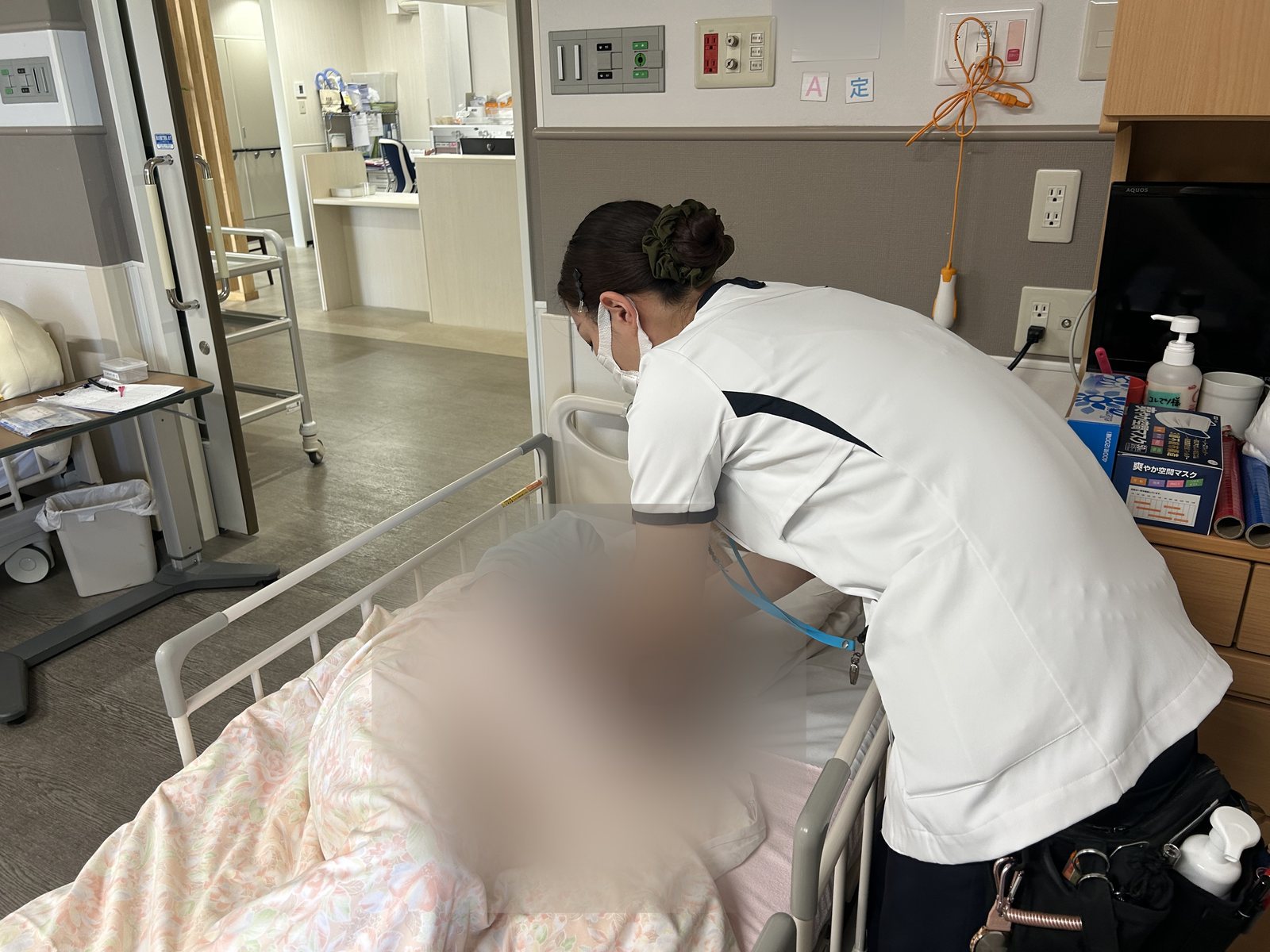 ベッドサイドで患者さんの状態を観察する看護師