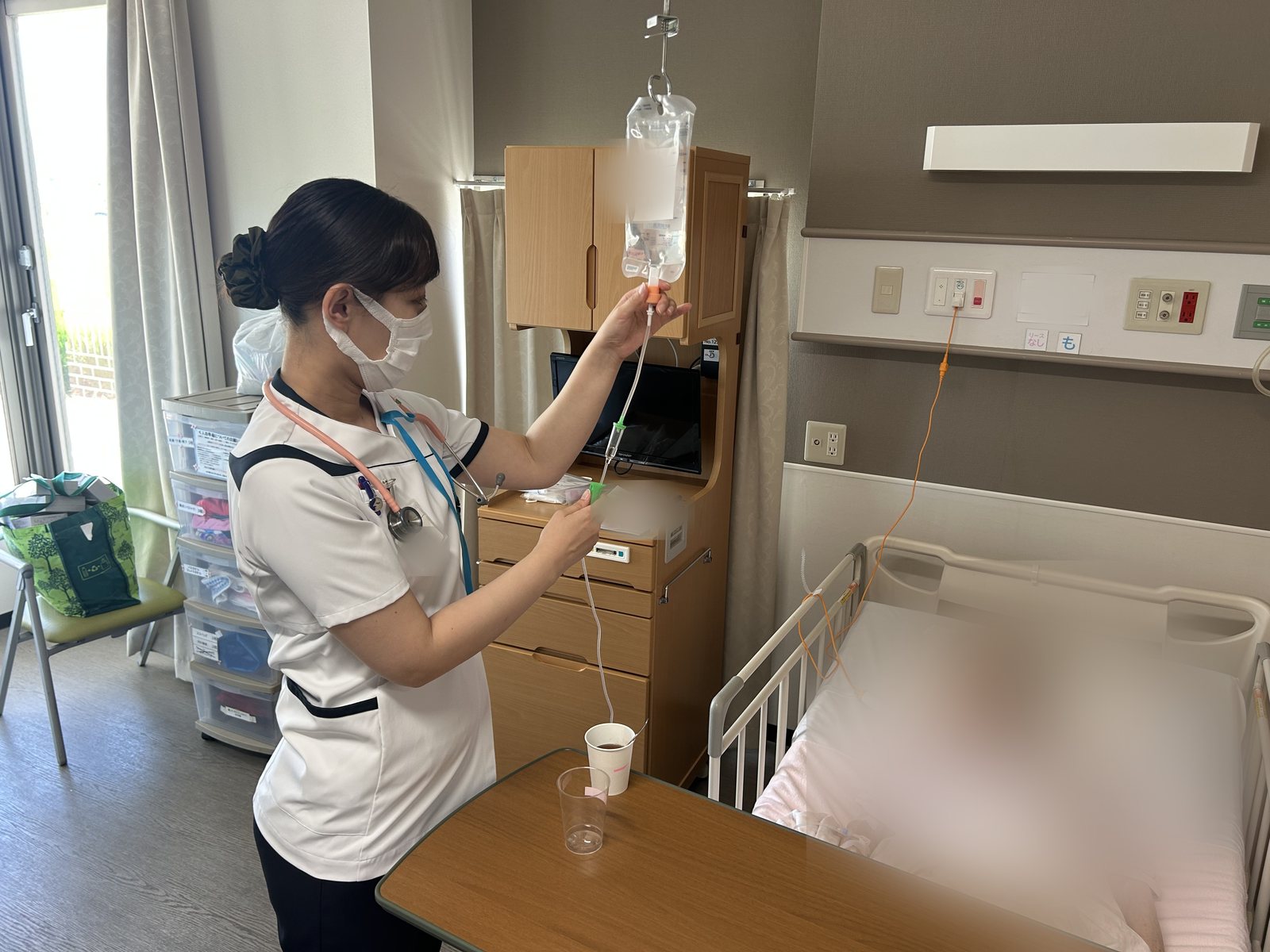 病室で点滴の準備をする看護師