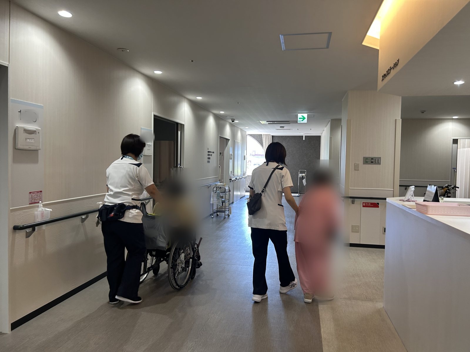 病棟の廊下で患者さんに付き添う看護師