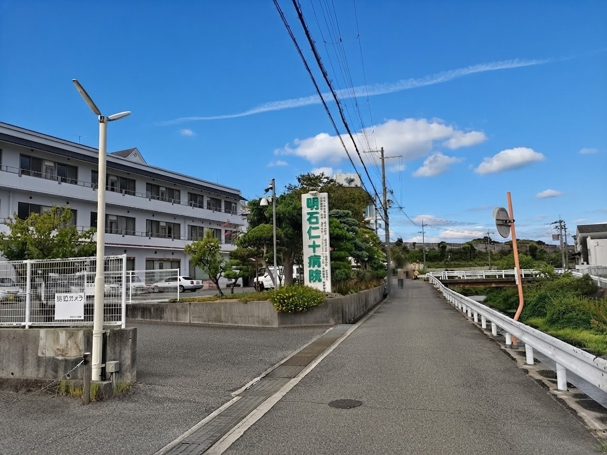 明石仁十病院の縦看板が立つ進入路